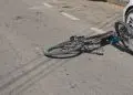 Bicicletă căzută lângă o mașină albă