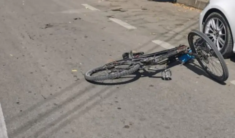 Bicicletă căzută lângă o mașină albă