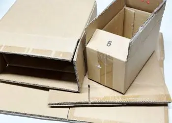 Cutii de carton pliate și una deschisă