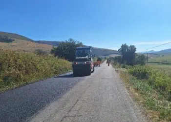 Compactor asfaltează un drum rural între dealuri