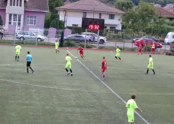 Meci de fotbal între echipe în galben și roșu