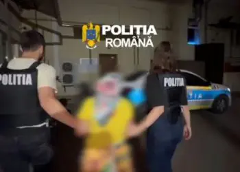 Polițiști români escortează o persoană cu fața blurată