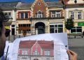 Arhitect ținând planul de restaurare în fața clădirii vizate de proiectul de modernizare din centrul istoric al municipiului Turda.