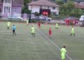 Meci de fotbal între echipe în galben și roșu