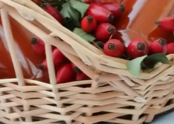 Coș cu sticle de sirop și măceșe roșii